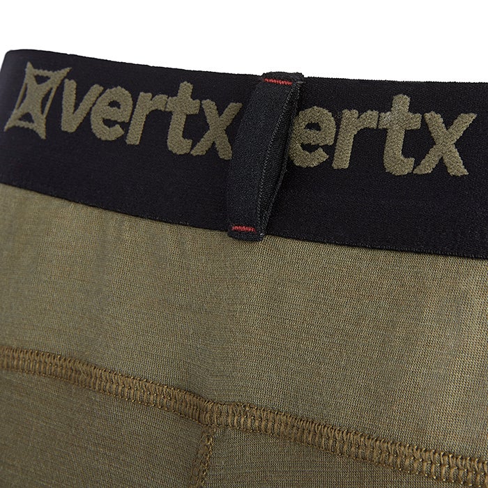 Close-up of Vertx brand olive-green baselayer underwear showing a black waistband with red stitching and a textured fabric