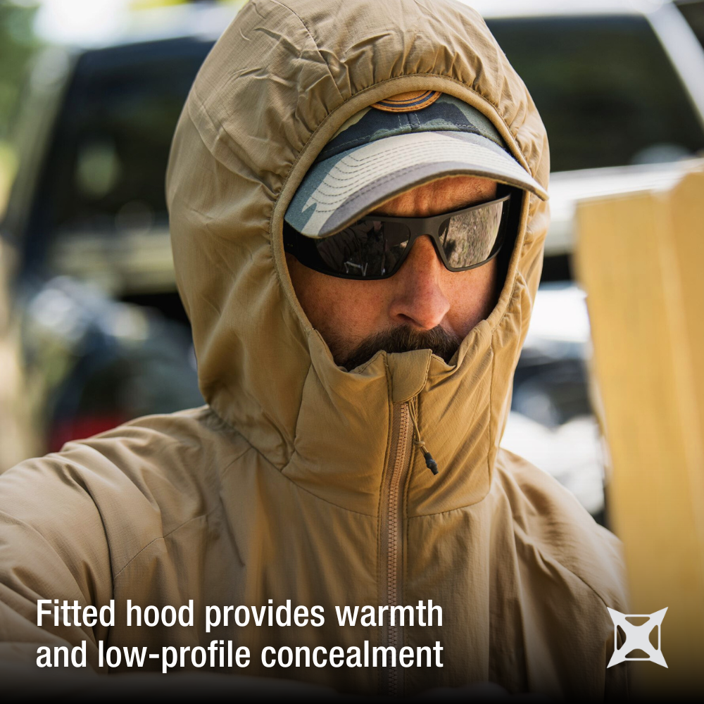 Photograph tan hooded jacket worn by a man outdoors featuring a camouflage baseball cap, dark sunglasses, and a partially visible vehicle in the background