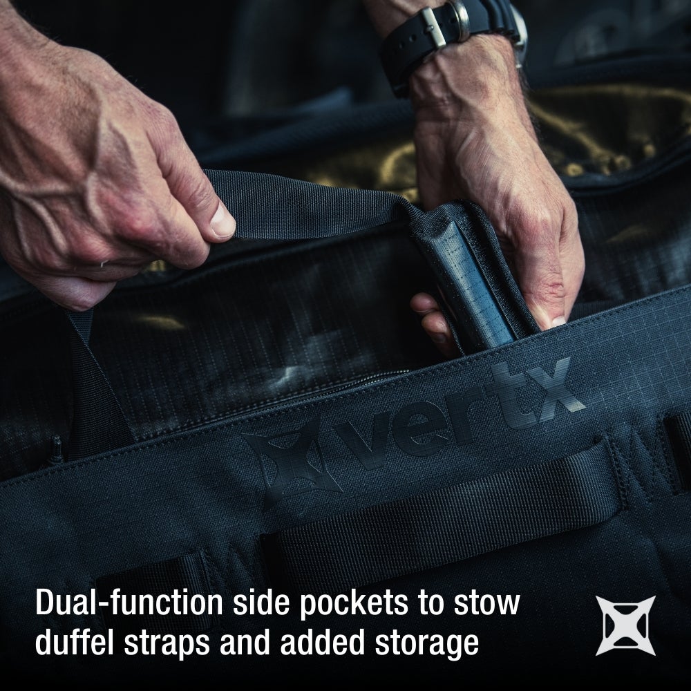 Product shot showing hands using a Vertex black duffel bag's dual-function side pocket with black straps and a textured logo showcasing added storage and a sleek design