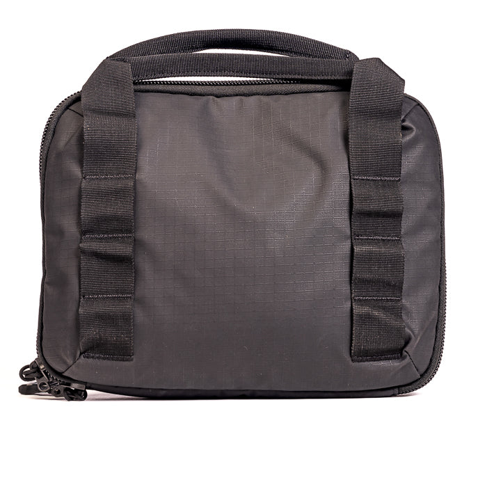Product photography of a black nylon carrying case with top handle and side straps featuring a textured surface reinforced stitching and zipper closure