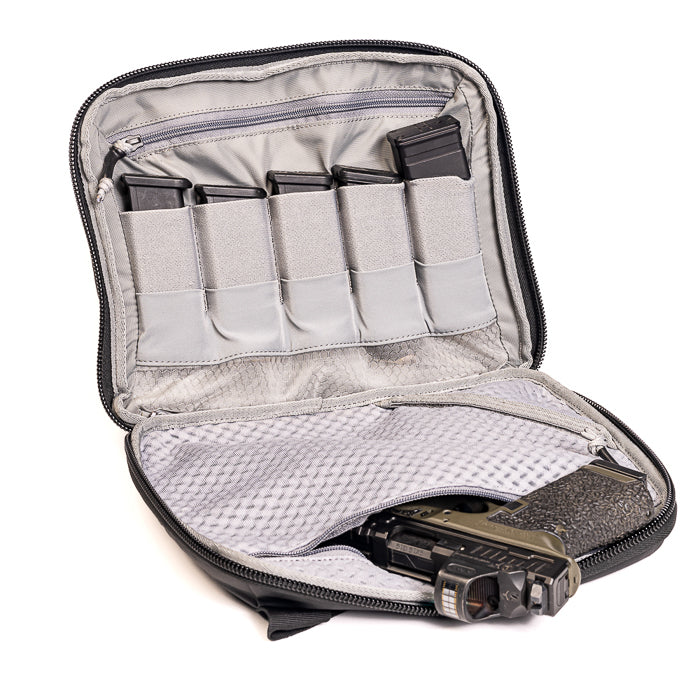 Product photography showing a black pistol case containing a handgun magazines and a gray patterned interior with multiple compartments