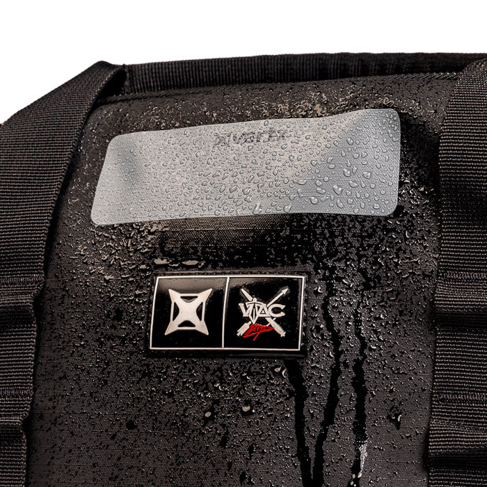 Product shot of a black ViaC gear bag featuring a water resistant label and logo showing water droplets and a reflective silver patch