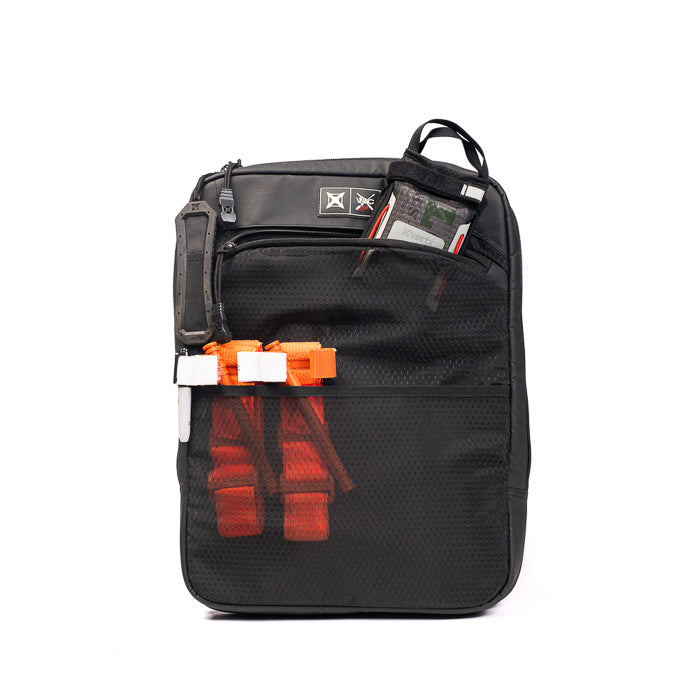 Product photography of a black backpack featuring orange straps, white clips, and a grey device in a mesh pocket