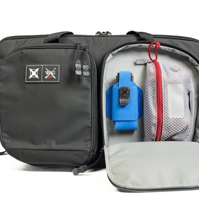 Product Photography WAC bag showing a black bag with gray and blue interior compartments featuring a blue pistol holster, red zippered pouch, and gray mesh pocket