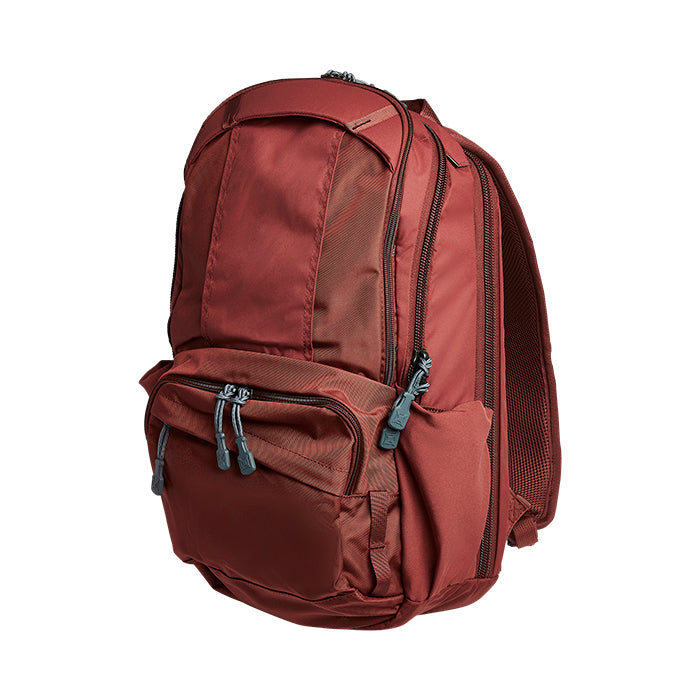 Product shot of a maroon backpack featuring multiple zippered compartments and gray accents on a white background