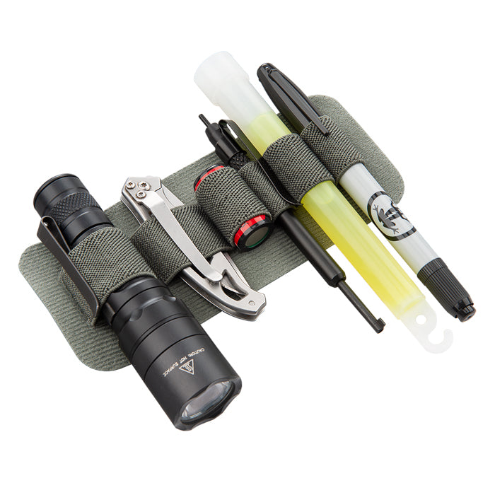 Product shot showing a gray fabric utility pouch holding a flashlight, pocketknife, pen, glowstick, and other tools on a white background