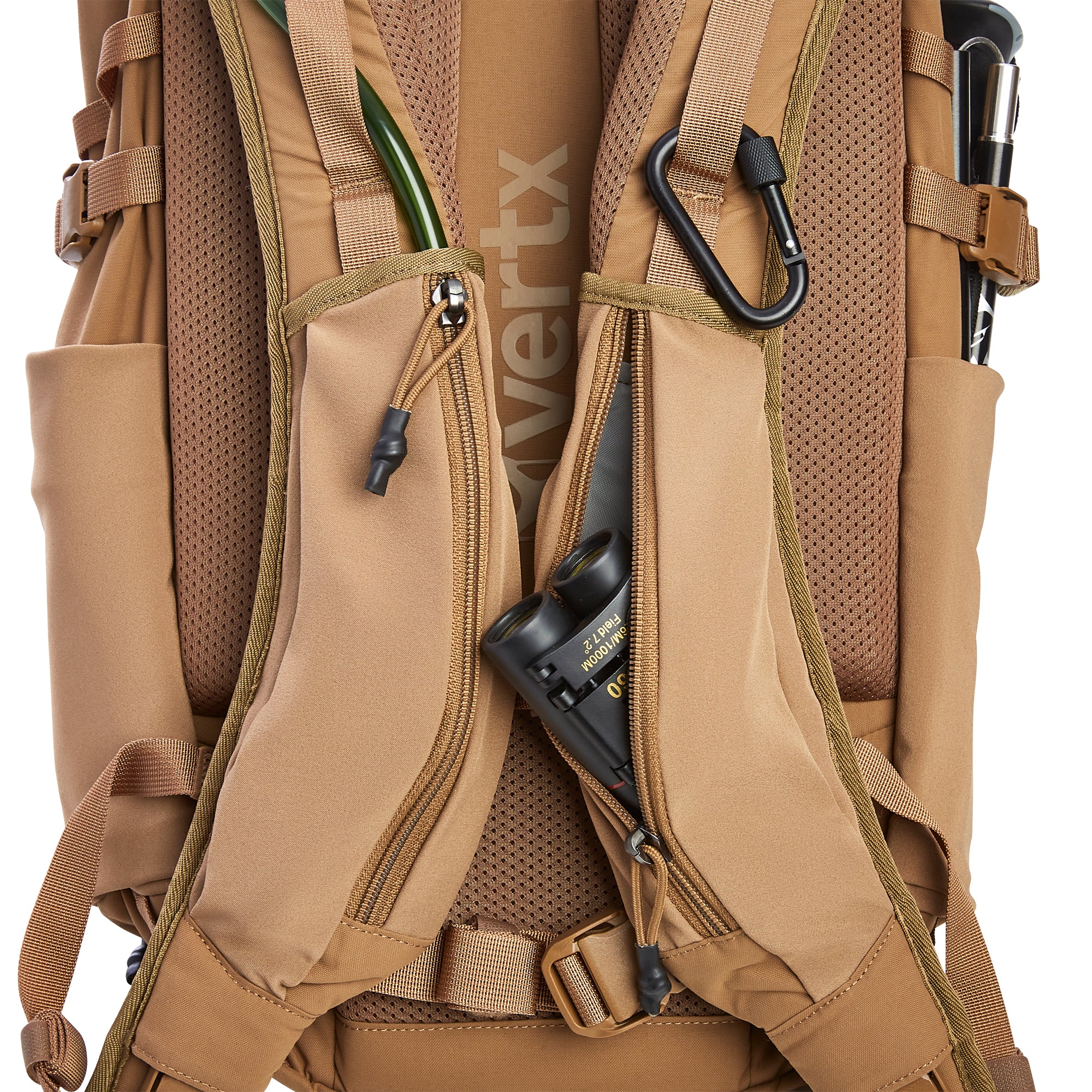 Vertx tan tactical backpack studio shot with a subtle Vertx logo, showing a green hydration tube, black carabiner, binoculars in a zippered pocket, and a trekking pole secured on the right side