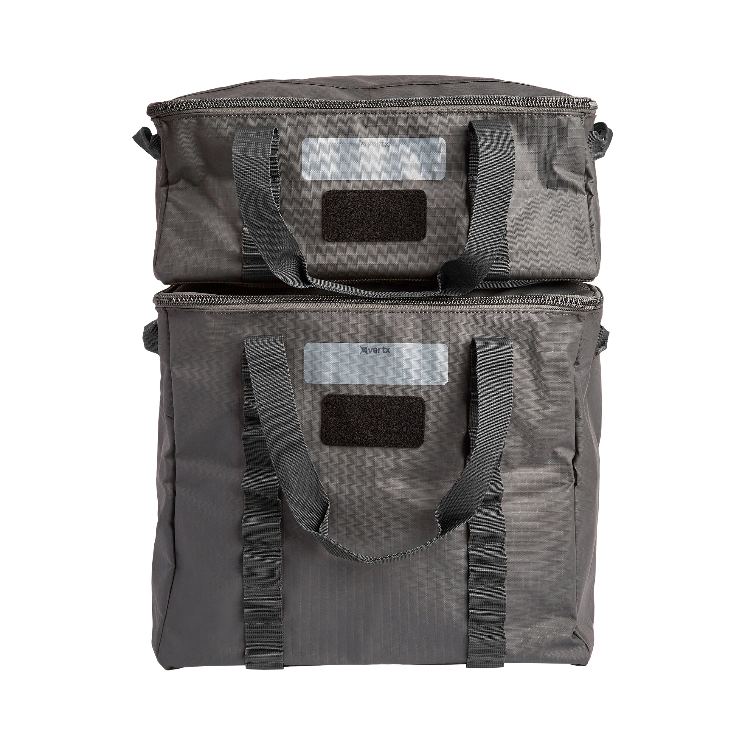 Product shot of two stacked Xvertx grey fabric zippered bags with dark grey handles and Velcro patches on a white background