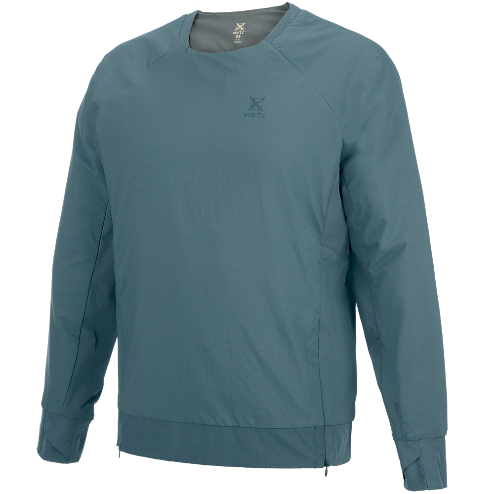 Product shot of a Vertx men's teal long-sleeved shirt featuring a subtle logo, raglan sleeves, and a zippered hem showcasing the brand's minimalist design aesthetic