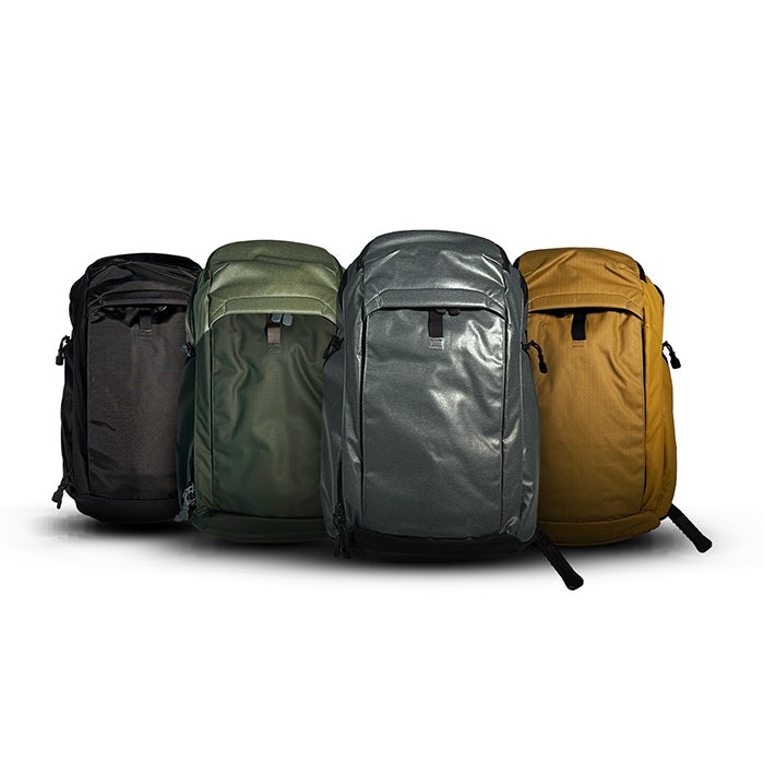 Product shot showing four different colors of backpacks black olive gray and gold against a white background