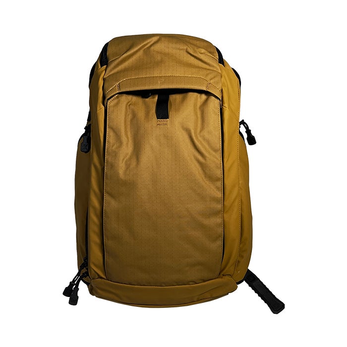 Product shot of a mustard-yellow Peak Design Travel Backpack featuring black accents, compression straps, and a subtle textured fabric