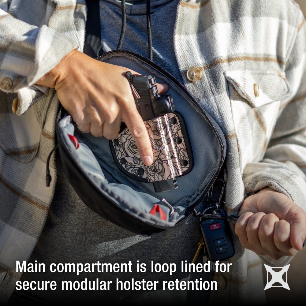 Photograph shows a person's hand removing a handgun from a rose-patterned holster inside a black bag featuring a gray interior and red accents