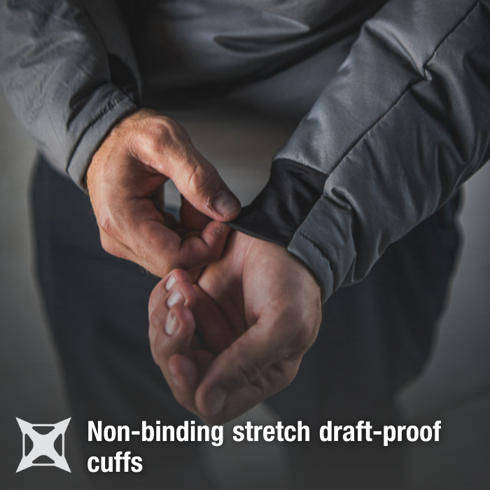 Product shot showing a person adjusting the non-binding stretch draft-proof cuffs of a gray jacket with black inner cuffs and detailed stitching