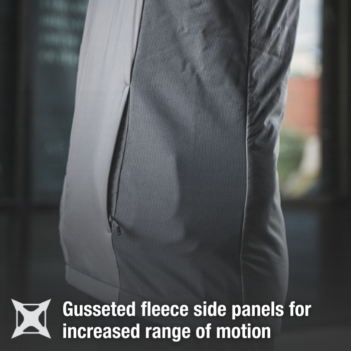 Product shot showing a gray and light gray fleece jacket with a gusseted side panel and zipper detail against a blurred background