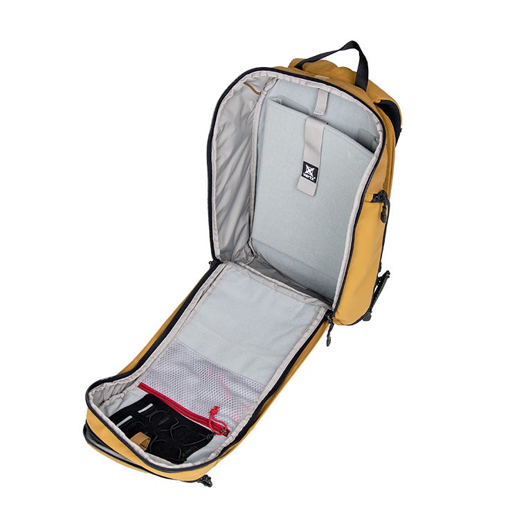 Product shot of a mustard-yellow Vertex backpack open to reveal its gray interior multiple pockets and a red zipper pull