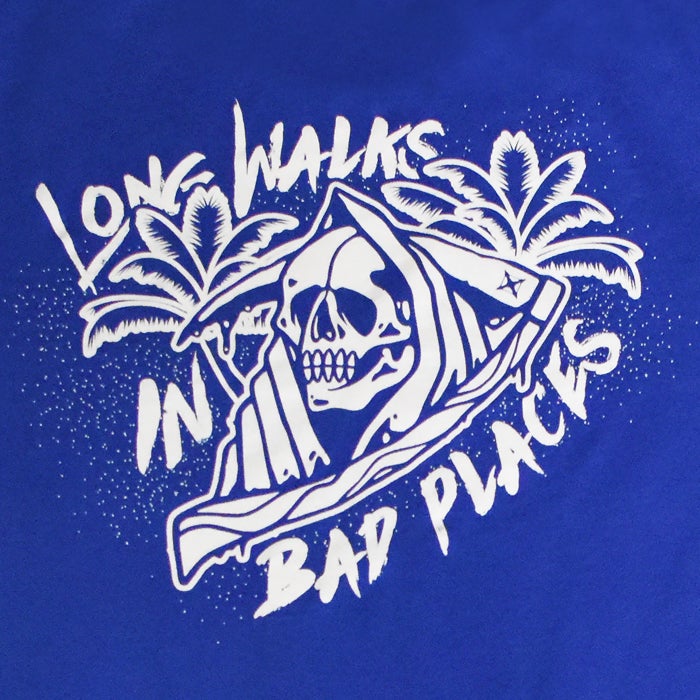 Unknown artist apparel graphic design featuring a hooded skull amongst palm trees on a royal blue background with the text Long Walks in Bad Places and stylistic drips and speckles