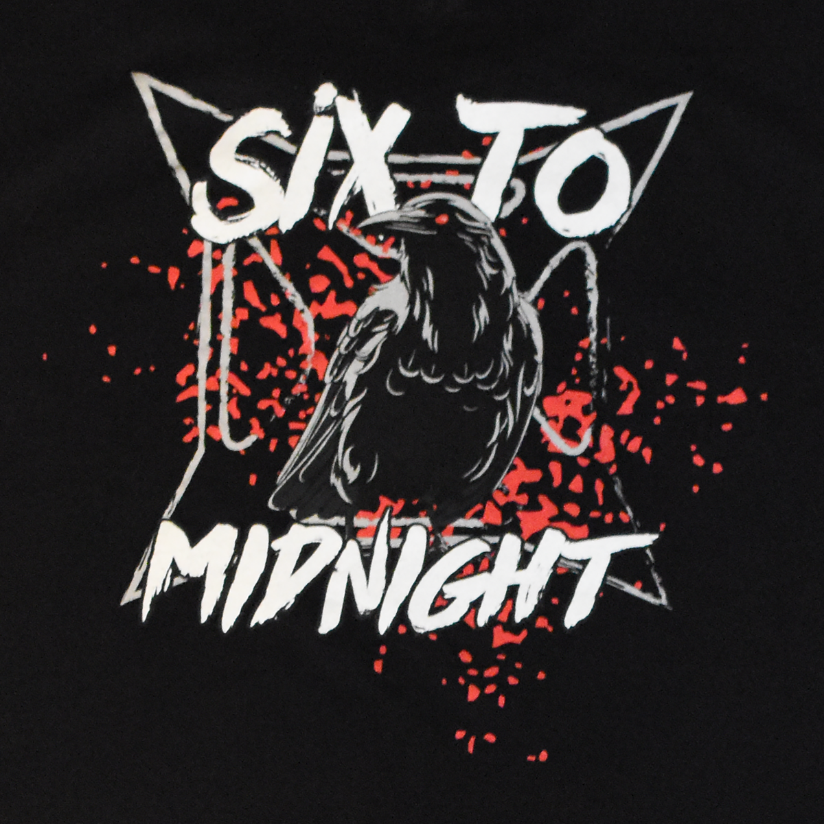 Digital artwork featuring a black crow centered on a black t-shirt design with a stylized starburst, red splatter accents, and the words Six To Midnight in bold white lettering