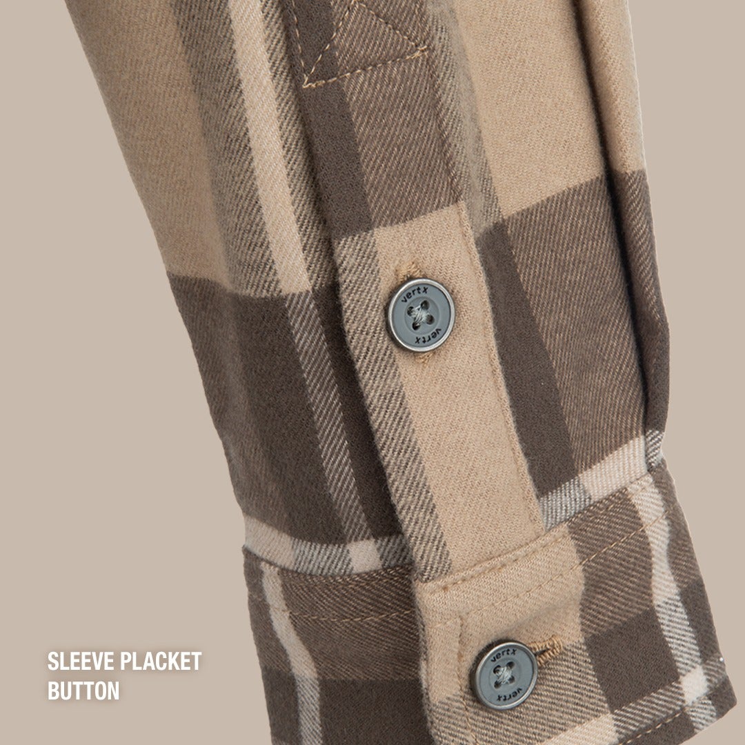 Close-up of a Vertx brand tan and brown plaid flannel shirt sleeve placket featuring two gray branded buttons and subtle stitching detail
