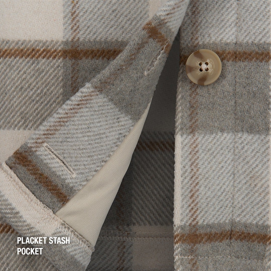 Close up of a beige and brown plaid textile showing a hidden pocket a large button and subtly textured weave