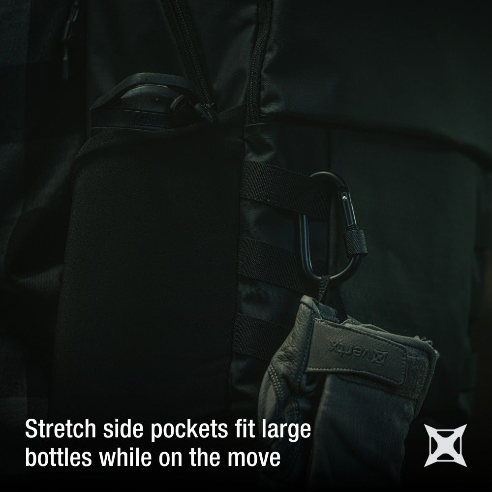 Product photography showing a black backpack with a water bottle in a side pocket, a carabiner, and olive-green gloves attached, featuring dark tones and subtle textural details