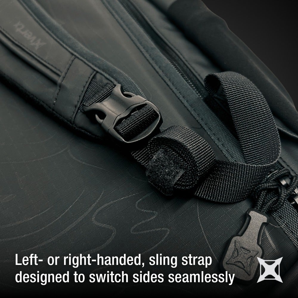 Product Photography Close-up of a black XOPAX sling bag strap showing a durable black plastic buckle, adjustable webbing, and subtle embossed detailing on the bag