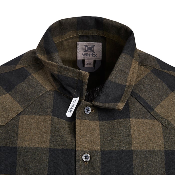 Close-up of a Vertx brand olive and black plaid flannel shirt showing its collar, label, and buttons featuring a soft texture and distinct stitching