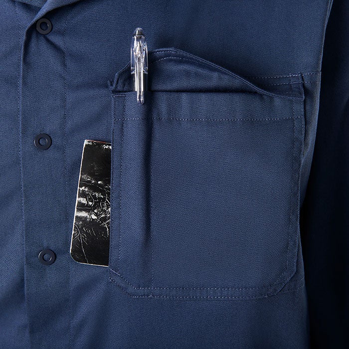 Close-up photo of a dark blue work shirt pocket containing a clear pen and a dark notebook with indiscernible imagery