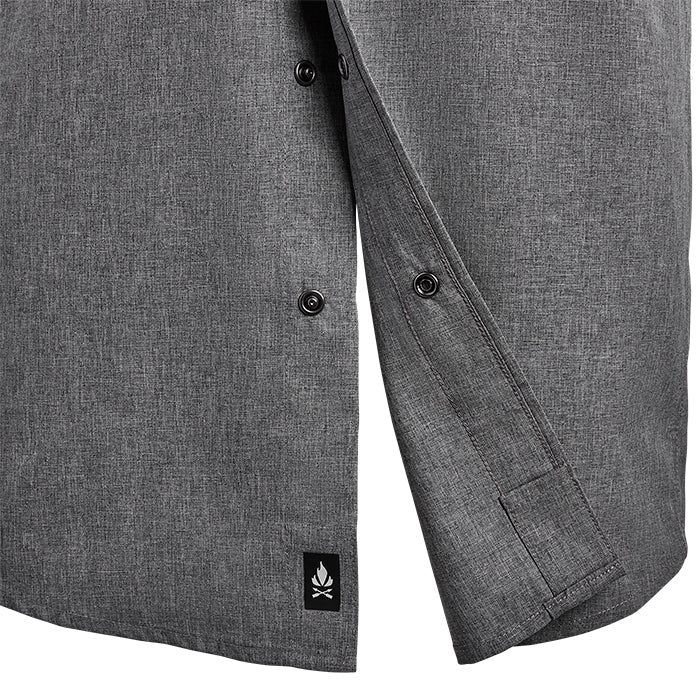 Product shot showing a charcoal grey button-down shirt with a small embroidered campfire logo and subtle textured weave featuring dark buttons and a unique cuff detail