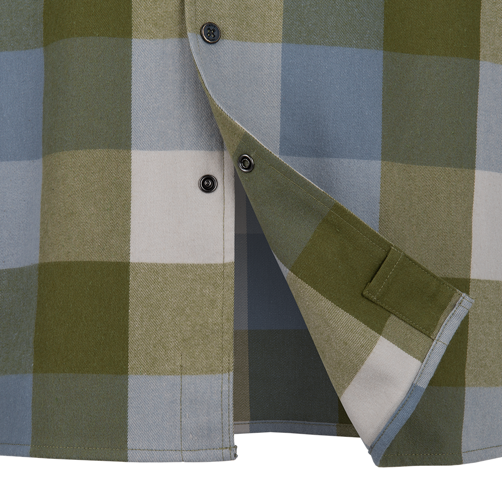 Close-up of a flannel shirt featuring olive green, dusty blue, and off-white checks showcasing a breast pocket and dark buttons