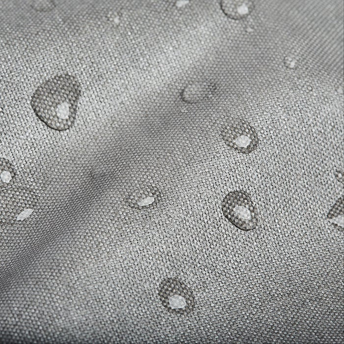 Close-up photograph of water droplets on a gray, textured fabric surface showing water resistance
