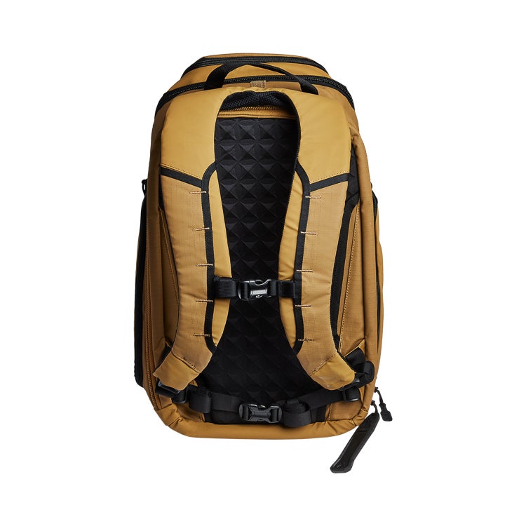 Product shot of a tan and black backpack featuring a quilted back panel adjustable straps and a small side handle