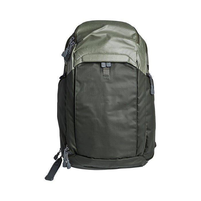 Product shot of a dark olive green and lighter olive green backpack featuring grey zippers and buckles on a white background