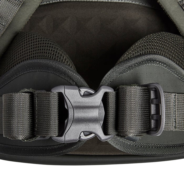 Close-up of a dark-olive-green backpack waist strap showing a durable plastic buckle, breathable mesh padding, and tightly woven nylon straps