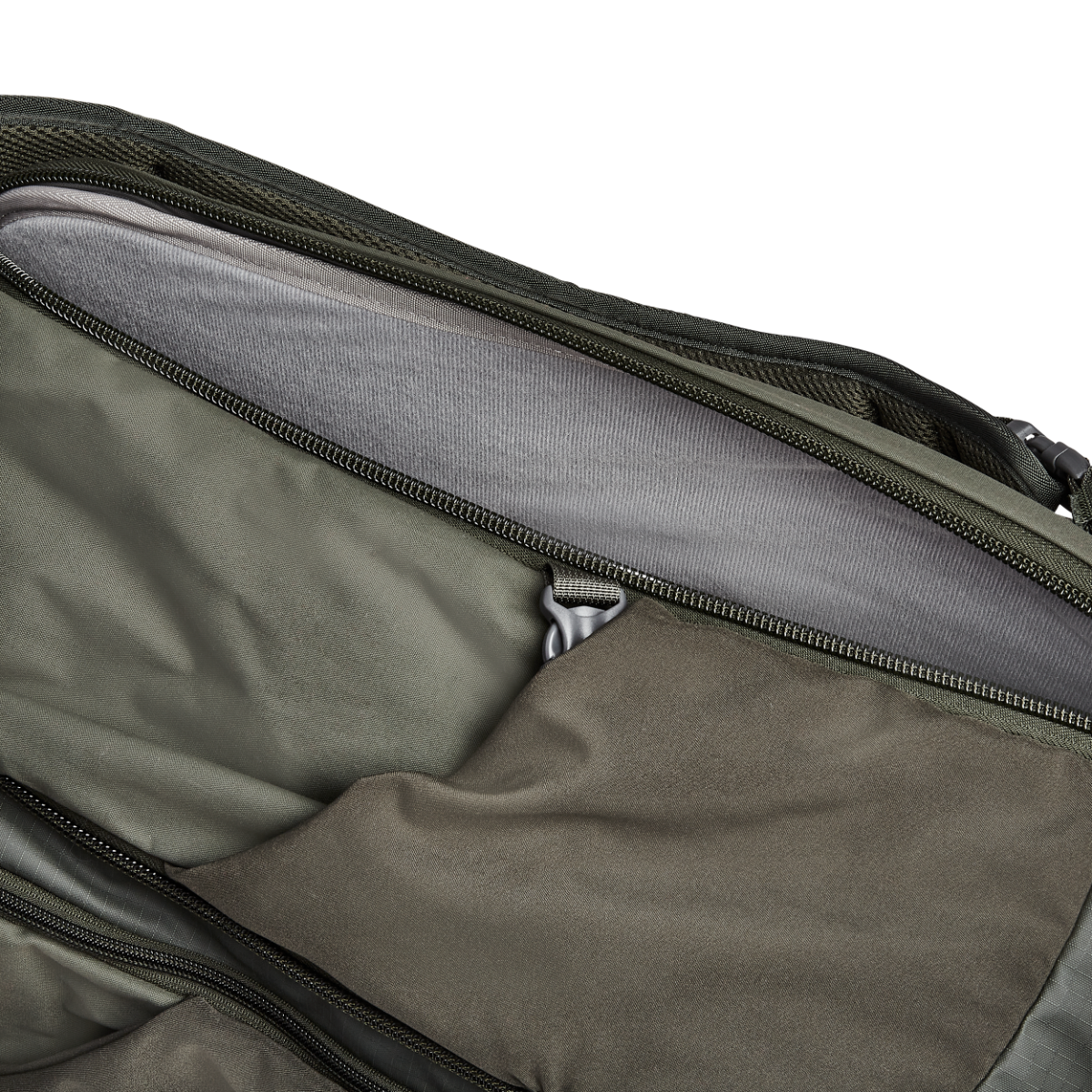Close-up photo of a green backpack interior showing a padded gray laptop sleeve a zippered pocket and olive drab fabric