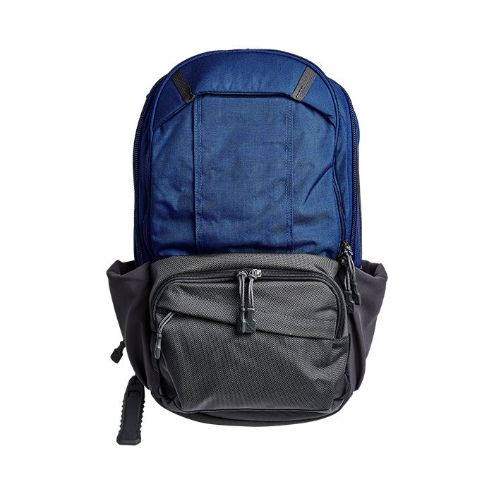 Product shot of a blue and gray backpack featuring a textured bottom compartment and two zipper pulls with unique detailing a side compression strap and ergonomic back panel