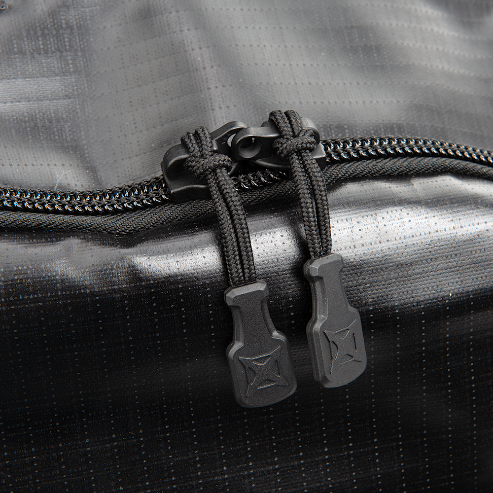 Close-up product shot of a black waterproof bag featuring dual zippers secured with black cords and unique plastic zipper pulls showcasing a subtle crosshatch pattern on the bag's surface