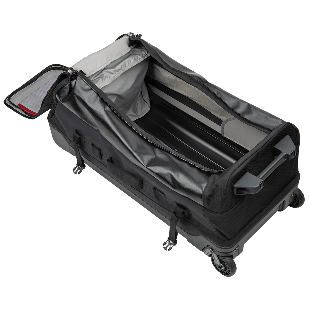 Product shot of a black wheeled duffel bag with gray interior compartments and red zipper pulls showing the spacious interior and easy maneuverability