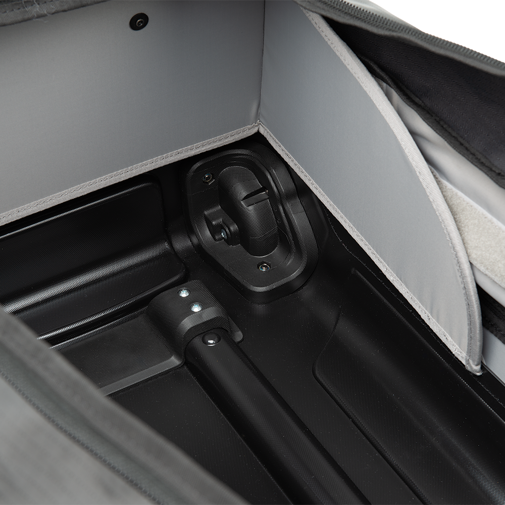 Close-up of a suitcase interior showing a gray fabric lining, a black telescopic handle, and a plastic locking mechanism with visible screws and a textured black base