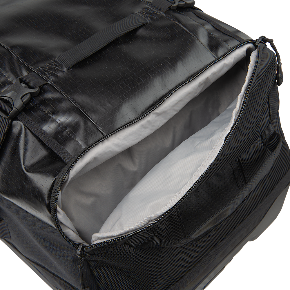 Product shot of a black travel duffel bag showing its spacious gray interior with durable zippers and reinforced straps
