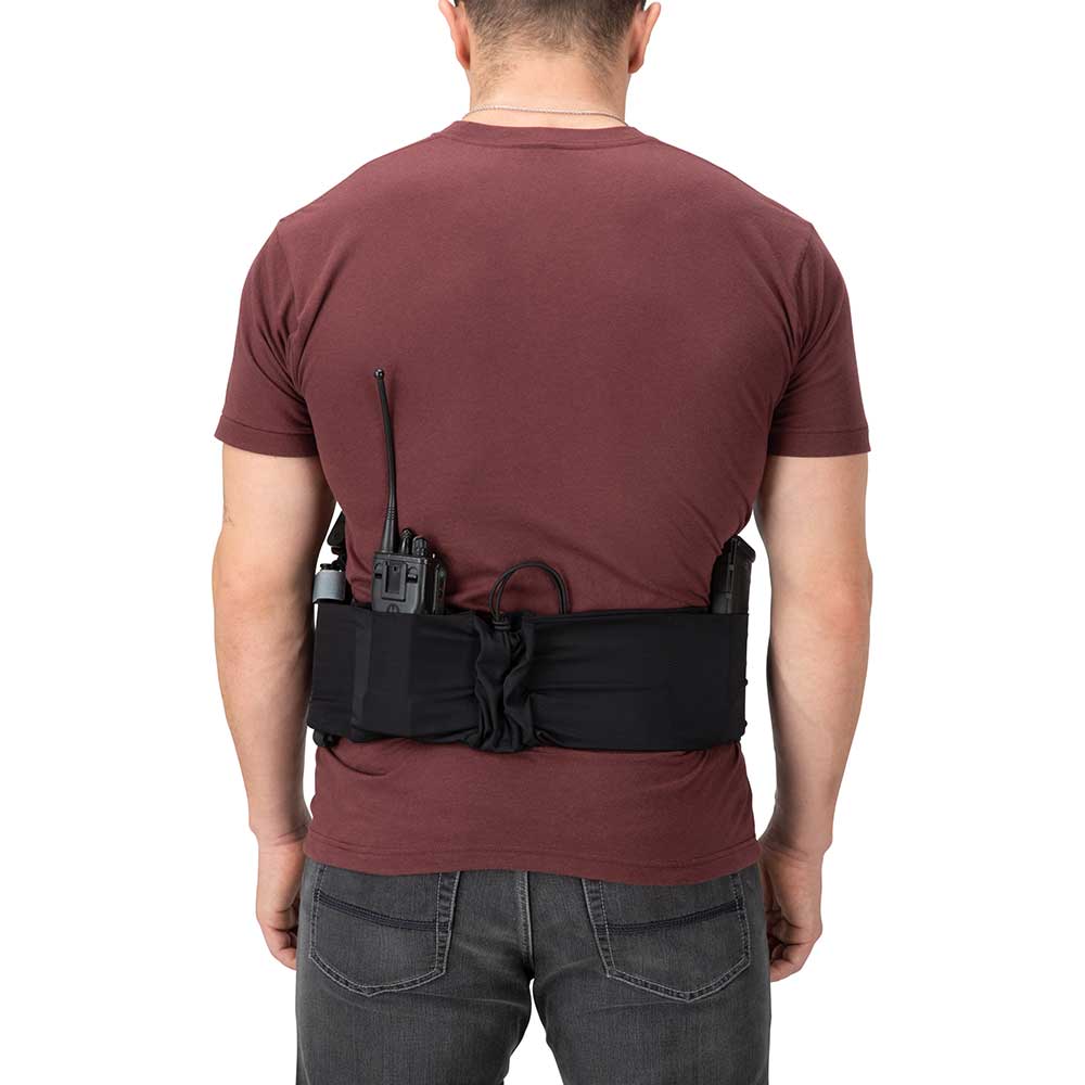 Product shot showing a person wearing a black tactical waistband holding a radio and handgun against a white background the waistband is adjustable and features a dark maroon shirt and gray jeans