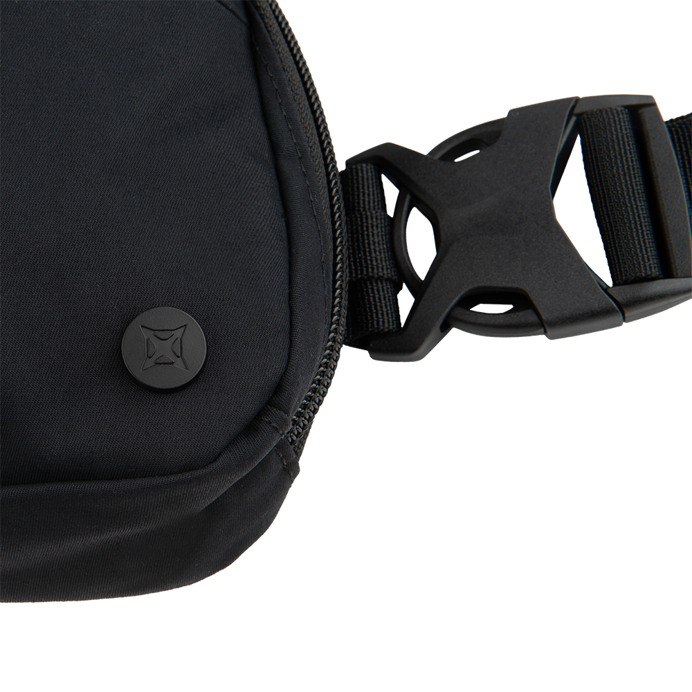 Product photography showing a black nylon crossbody bag with a zipper closure a unique logo button and adjustable black plastic buckle straps