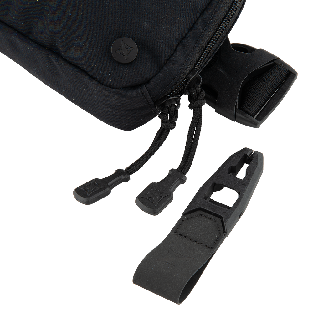 Close-up product shot of a black Hill People Gear Kit Bag showing zipper pulls, a plastic buckle, and branded toggles