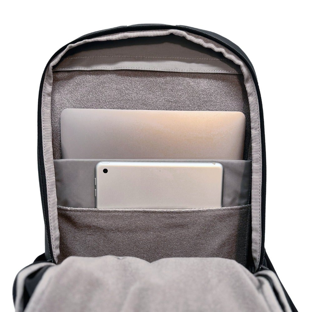 Product shot showing a black backpack's interior with a laptop tablet and gray cushioned compartments showcasing its organizational features
