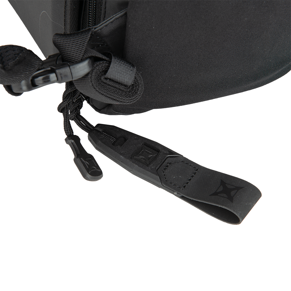 Close-up product shot of a black bag's zipper pull featuring a textured leather tab, a cord lock, and embossed branding showing subtle stitching details