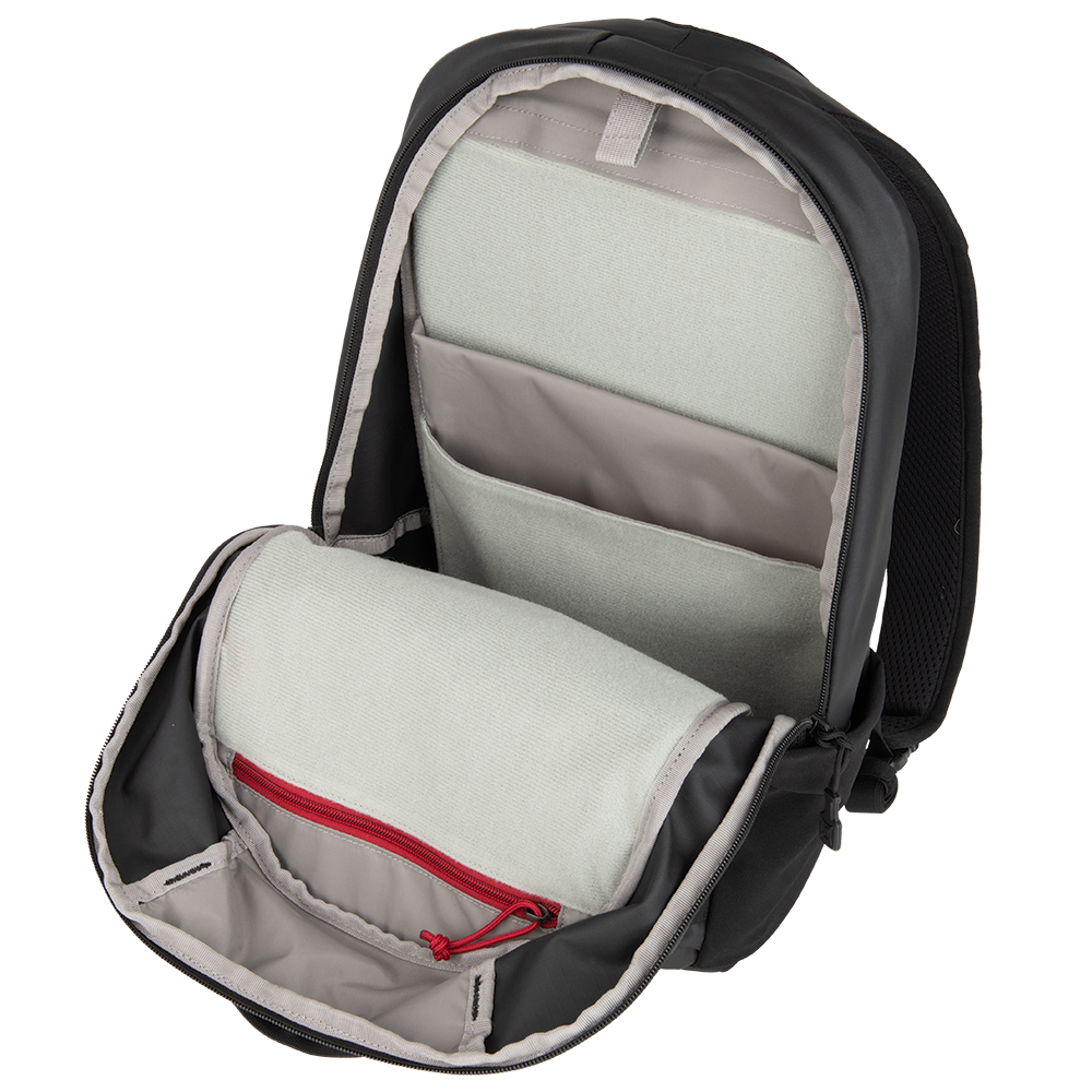 Product shot of a black backpack interior showing multiple grey compartments a red zipper pull and padded laptop sleeve
