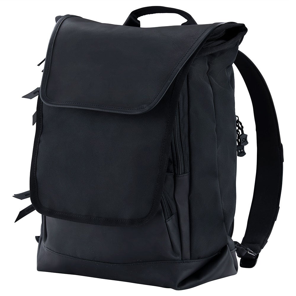 Product shot of a black leather and nylon backpack featuring a flap closure, zippered pockets, and adjustable straps.