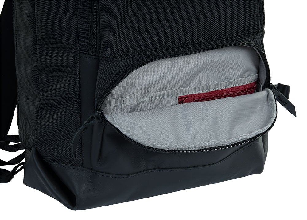 Product image showing the interior of a black leather backpack with a gray lining a burgundy zipper detail and multiple organizational pockets