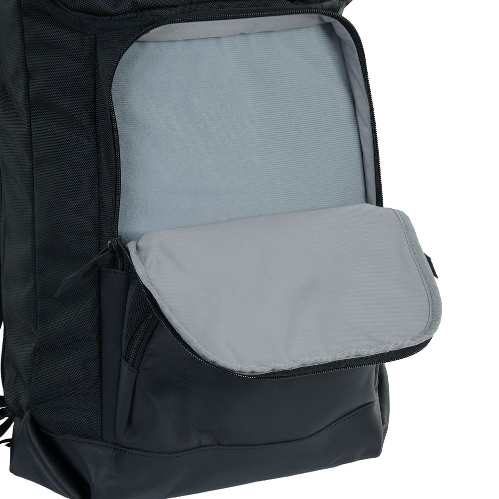 Product shot showing the interior of a black leather backpack with a gray fabric lining and zippered pockets featuring soft textured materials and smooth black leather accents