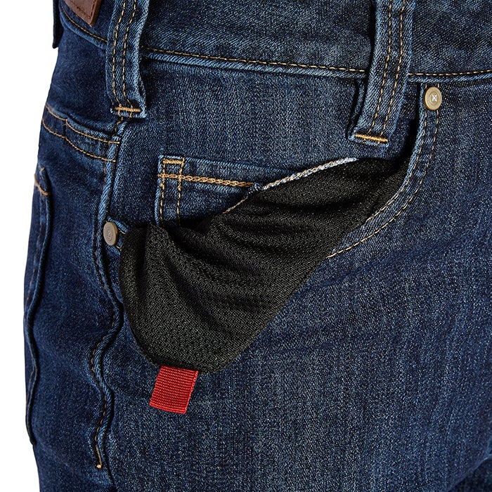 Close-up of dark wash denim jeans showing a black inner pocket with a small red label and contrasting stitching details