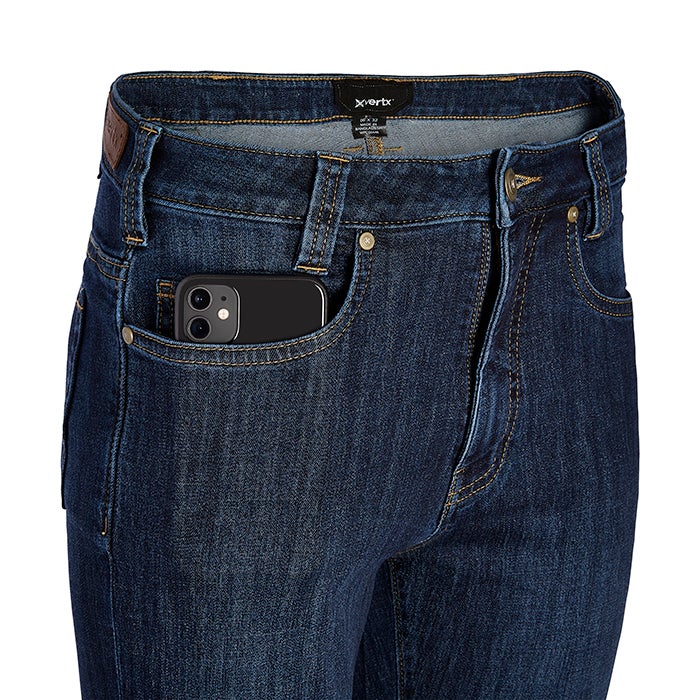 Product shot of XVertx jeans showing a smartphone in a front pocket with dark wash denim and brown leather label detail